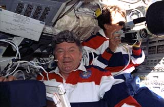 Mission specialists Valery Ryumin and Franklin Chang-Diaz with video camera in shuttle's flight deck.